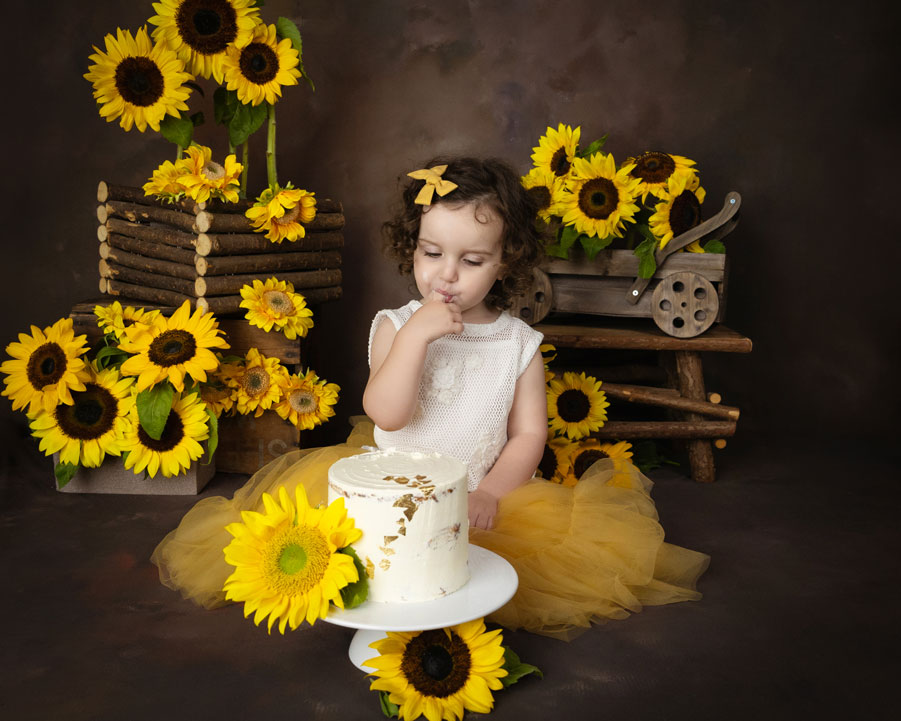 baby girl with birthday cake with sunflowers