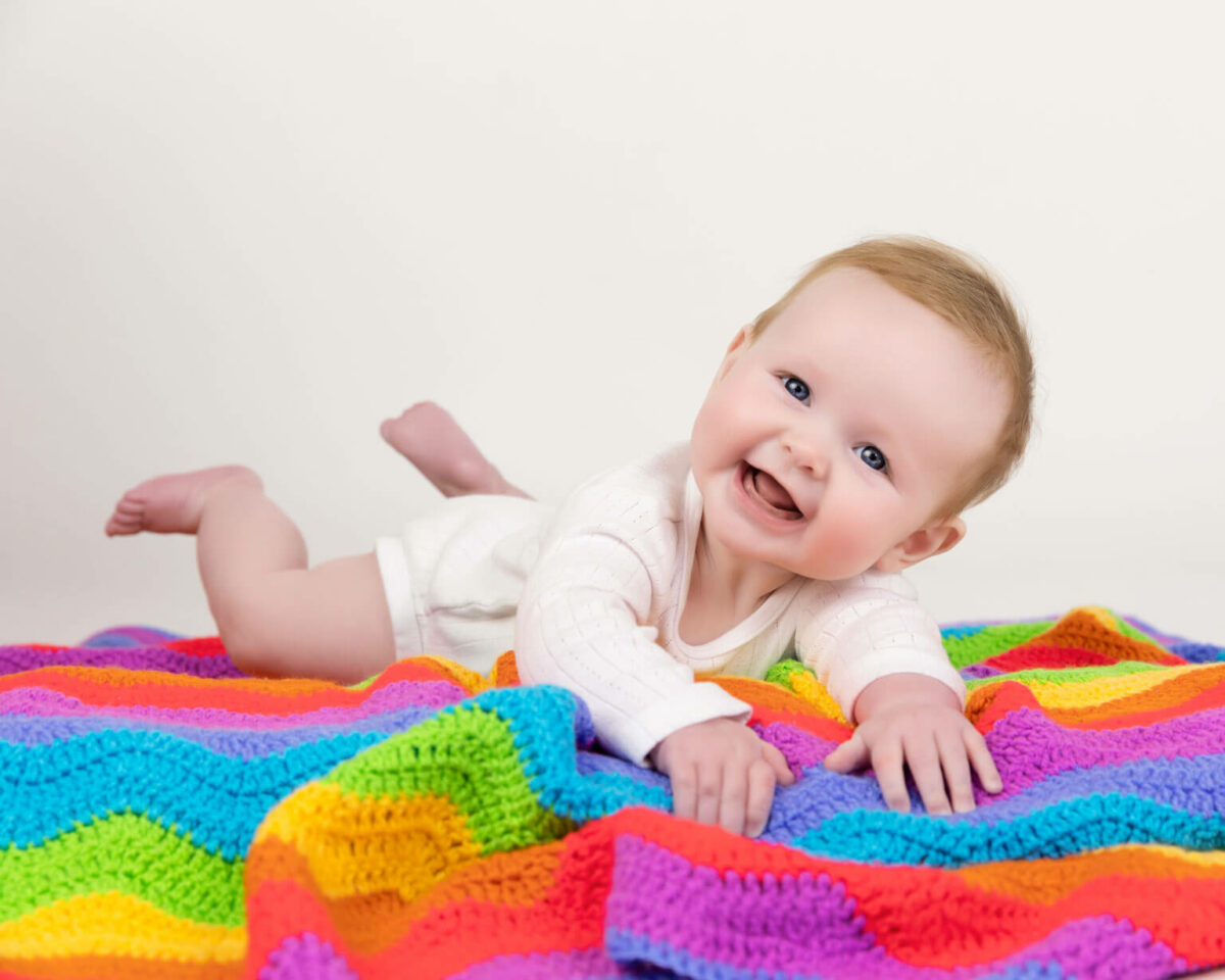 baby girl on rainbow blanket