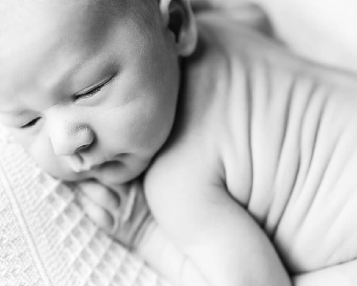 close up newborn baby sleeping black and white photography