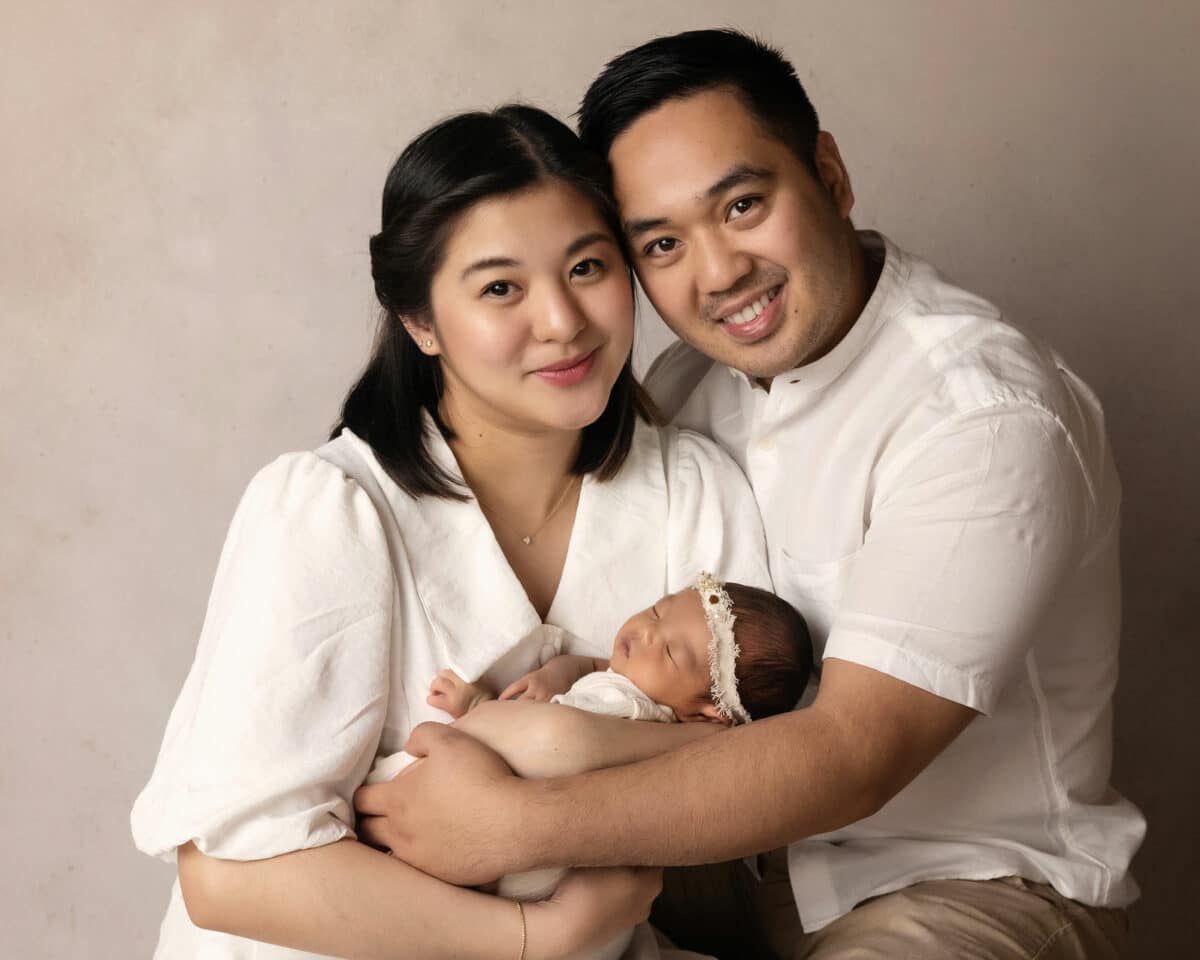 mum and dad holding newborn baby in white photography