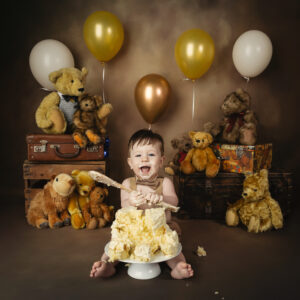 baby happy with wooden spoon and birthday cake with teddy bears
