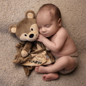 newborn baby in brown hugging teddy photography
