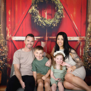 family Christmas photo with Christmas wreath and Christmas trees