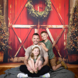 dad and kids Christmas photo with Christmas wreath and Christmas trees