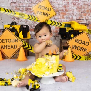 baby eating birthday cake with construction theme