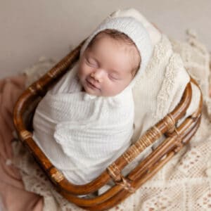 newborn baby in white in basket photography