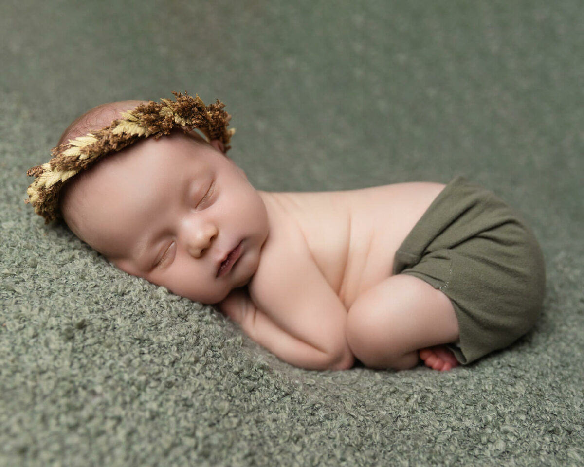 sleeping newborn baby in green with crown photography